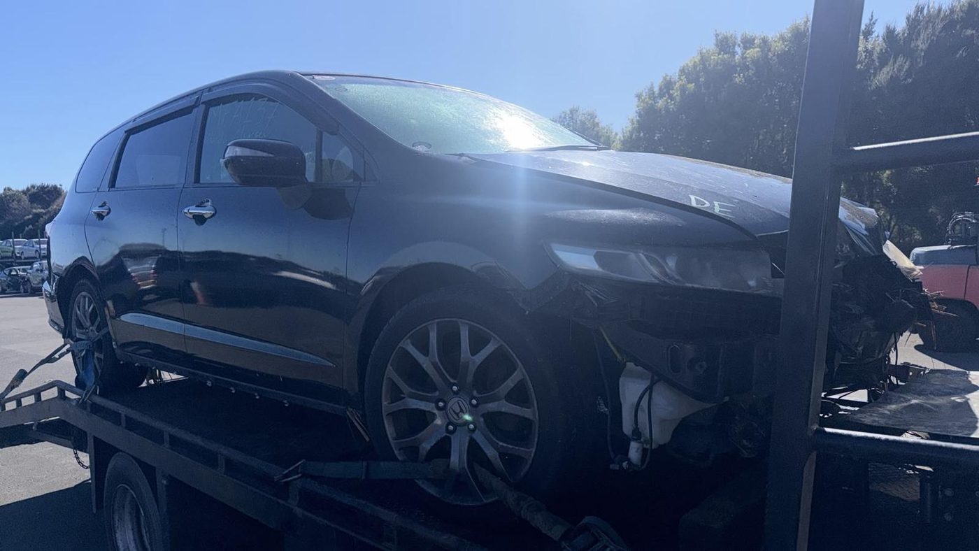 Written-off, crash-damaged Honda people-mover on an Auckland recovery truck