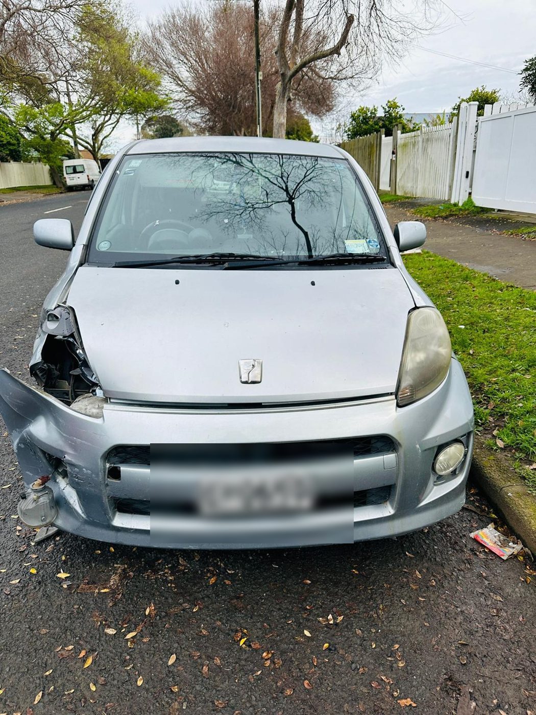 Front-damaged silver Toyota Passo ready for removal in Auckland
